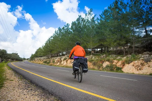 Biciclista está na estrada em dia ensolarado — Fotografia de Stock