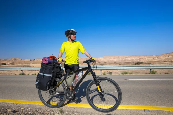 Biciclista em amarelo T-shirt passeios na estrada — Fotografia de Stock