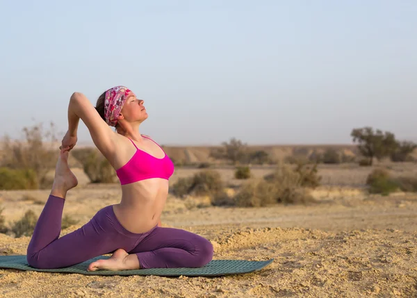Mujer joven haciendo yoga en el desierto al amanecer — Foto de Stock