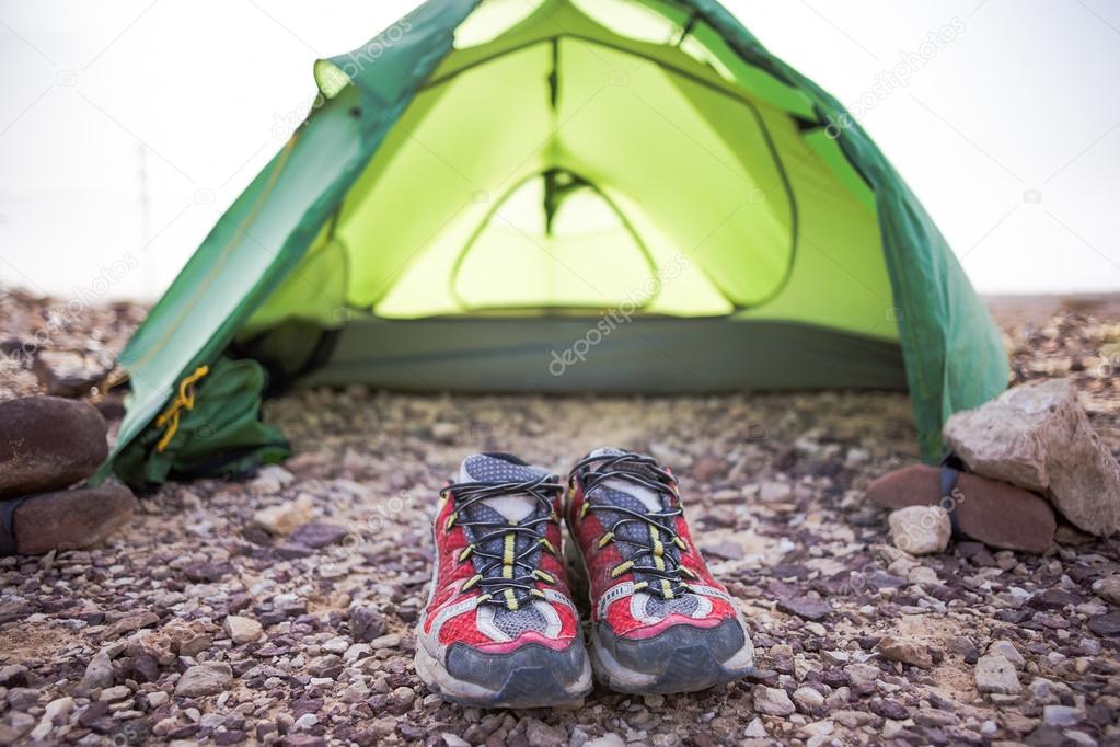 Green tent and red sneakers in sunny morning