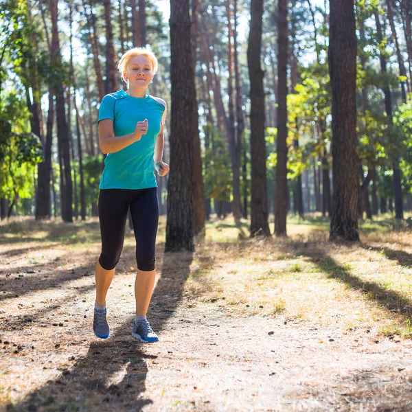 Läuferin trainiert auf Waldweg in schöner Natur. — Stockfoto