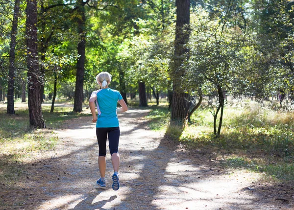 Löpare kvinna utbildning på skogsvägen i vacker natur. — Stockfoto