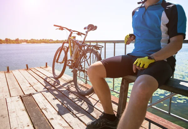 Bicyclist relaxing on pier — Stock Photo, Image