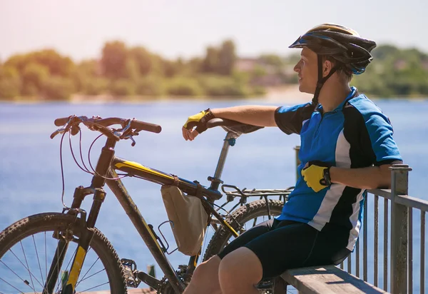 Rowerzysta relaks nad rzeką — Zdjęcie stockowe