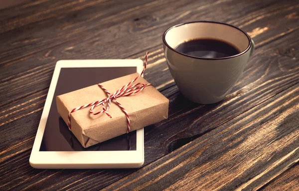 Таблетка, чашка кофе и подарок — стоковое фото