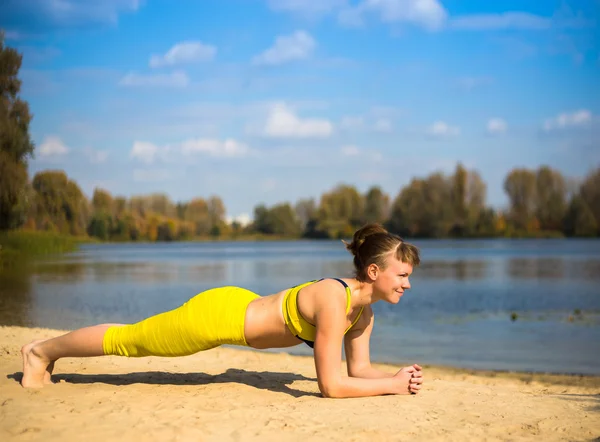 Mujer haciendo yoga cerca del río — Foto de Stock