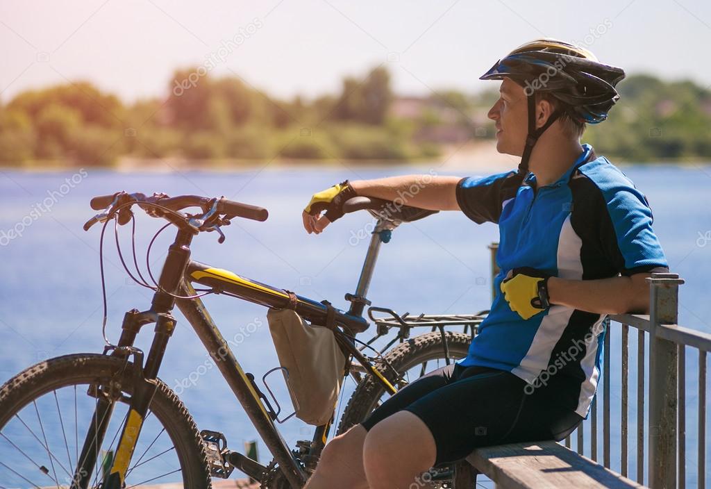 bicyclist relaxing near river