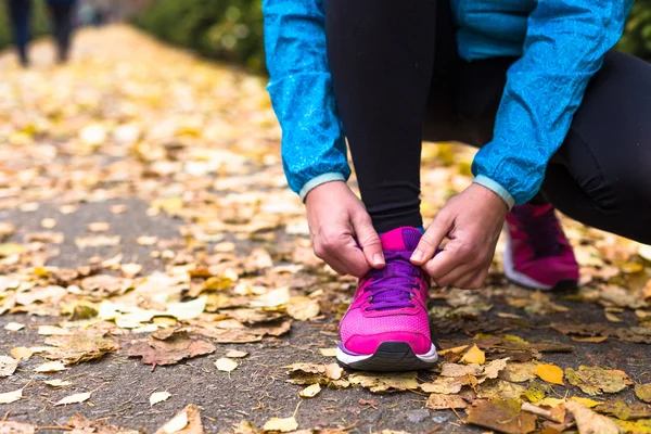 Deporte mujer atando zapatillas — Foto de Stock