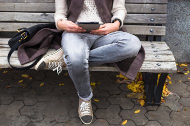 Mutlu hipster tablet pc şehir parkında sonbaharda tutarak.