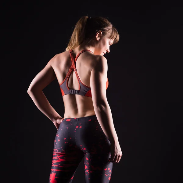Vacker ung och vältränad fitness sport modell poserar i mörka studio — Stockfoto