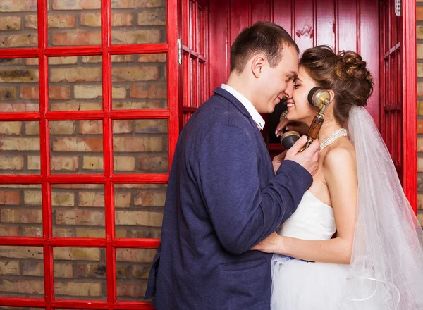 Νέους γάμο ζευγάρι, θέτοντας σε κόκκινο Ελληνικά τηλεφωνικούς — Φωτογραφία Αρχείου