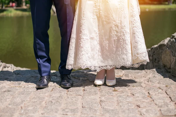 Pareja de boda de pie cerca del río en un día soleado. Novia y novio felices —  Fotos de Stock