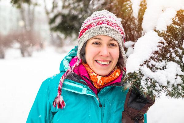 Young happy woman enjoy snow in winter city park outdoor