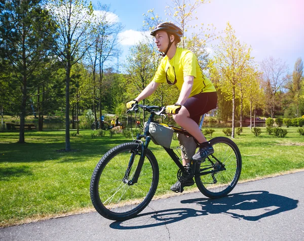 Jóvenes paseos en bicicleta en el parque de la ciudad —  Fotos de Stock