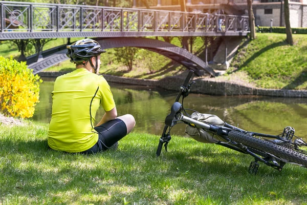 Biciclista tendo descanso no parque da cidade — Fotografia de Stock