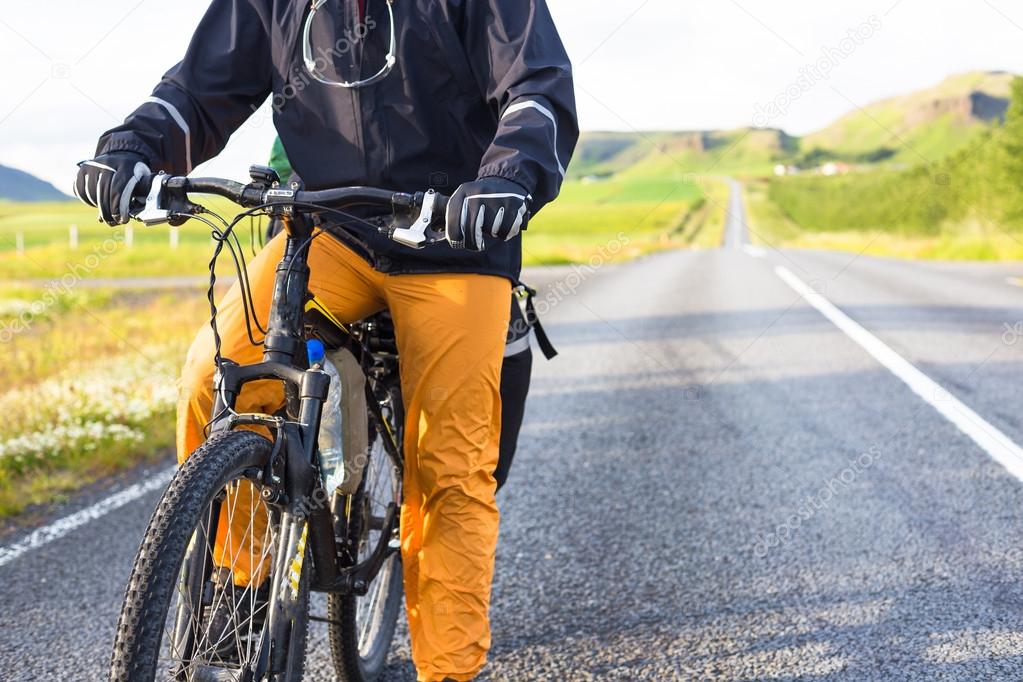 Happy biker rides on road in Iceland