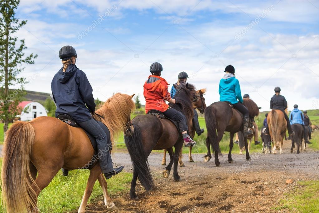 Group of horseback riders ride in Iceland