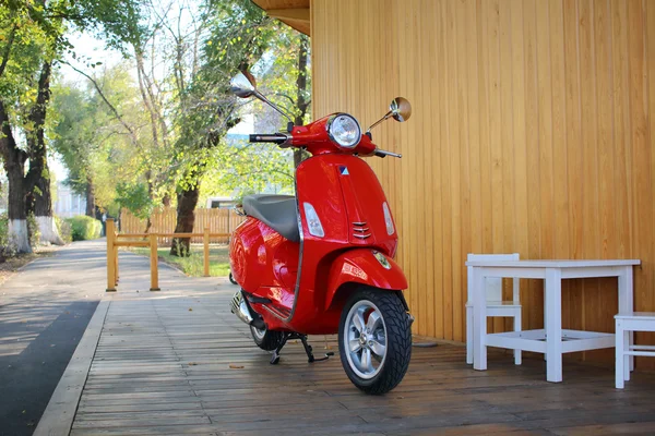 Rode scooter in de buurt van het café Stockfoto