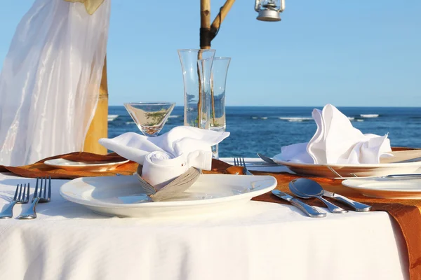 Blaues Meer und ein Tisch für ein romantisches Abendessen am Strand — Stockfoto