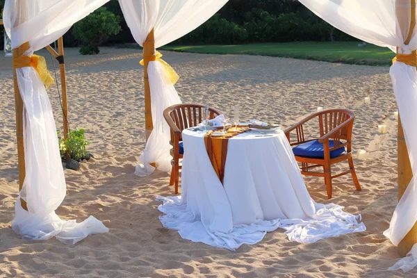 Tent en een tabel voor een romantisch diner op het strand Stockfoto