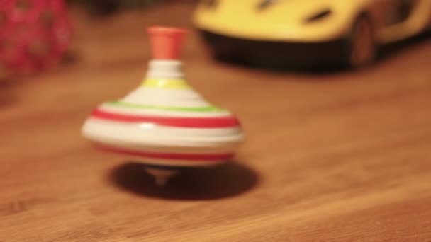 Giroscópio de fiação de brinquedo no chão marrom — Vídeo de Stock