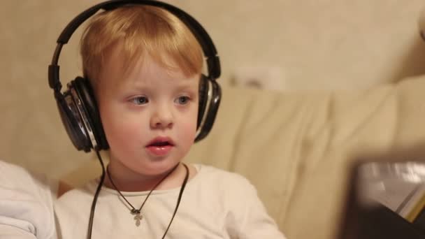 Młody chłopak jest posłuchać muzyki w słuchawkach — Wideo stockowe