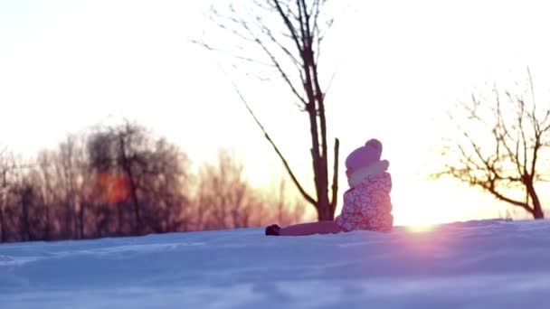 Kleines Mädchen spielt im Wintersonnenuntergang — Stockvideo