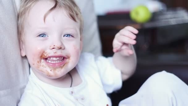Kleine jongen die chocolade eet en mond vol tanden. — Stockvideo