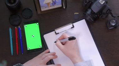 Bir adam bir kalem kağıt kelime para üzerinde yazıyor.