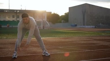 Isınma önce egzersiz yapıyor ve koşu genç atletik erkek