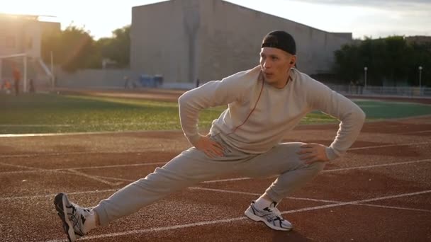 Молодой спортсмен делает разминку перед тренировкой и пробежкой — стоковое видео