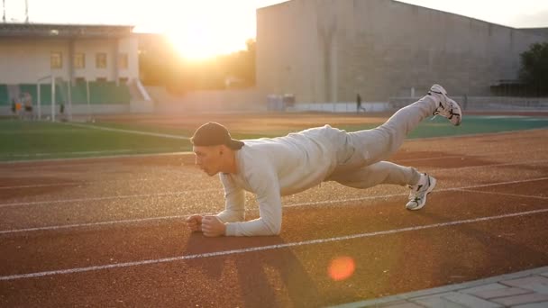 Молодий атлетичний чоловік робить розминку перед вправами і бігом — стокове відео