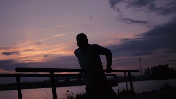 Hombre fuerte haciendo Pull Ups Al aire libre bajo el sol muy caliente en un parque — Vídeos de Stock