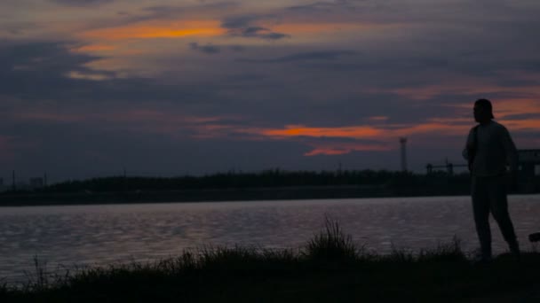 Homem andar na praia, parar e andar novamente, tempo de pôr do sol profundo — Vídeo de Stock