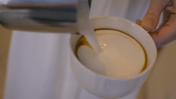 Das Mädchen gießt eine Tasse weiße Milchcreme ein — Stockvideo