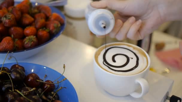 Barista disegna cioccolato art caffelatte sulla tazza bianca — Video Stock