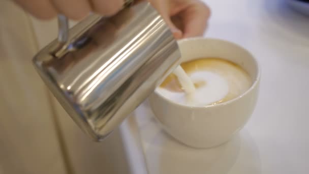 La chica vierte en una taza de crema de leche blanca — Vídeo de stock