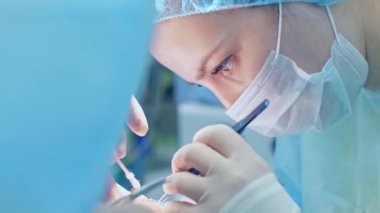 Cerrah kadın hastaya ameliyat yapıyor.