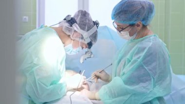 Cerrah kadın hastaya ameliyat yapıyor.