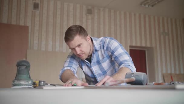Carpinteiro faz marcas de lápis no branco com a ajuda de uma régua — Vídeo de Stock