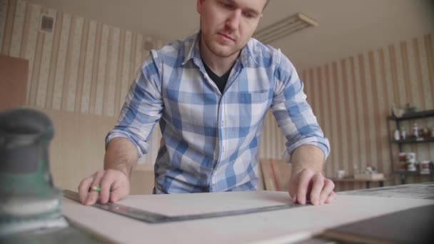 Carpinteiro faz marcas de lápis no branco com a ajuda de uma régua — Vídeo de Stock