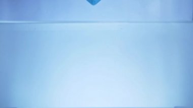 Banyo tuzu akvaryuma düşer. ağır çekim