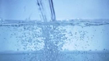 Akvaryuma yavaş çekimde, arka planda ve kabarcıklarda su dökün