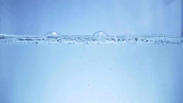 Налейте воду в аквариум в замедленной съемке, на заднем плане и в пузырьках — стоковое видео