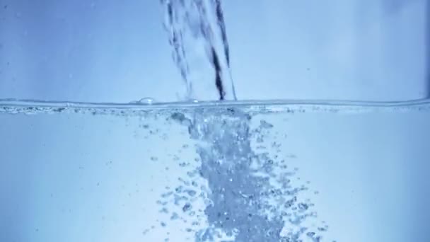 Hæld vand i akvariet i slowmotion, baggrund og bobler – Stock-video