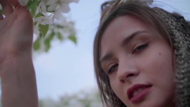 Una linda chica con rastas posa junto a un árbol con hojas — Vídeo de stock