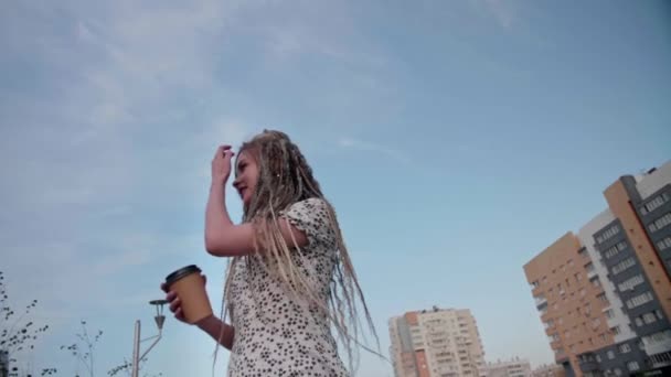 Chica joven con rastas con café paseos por la calle — Vídeos de Stock