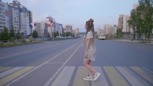 Una chica con rastas caminando por un camino — Vídeos de Stock