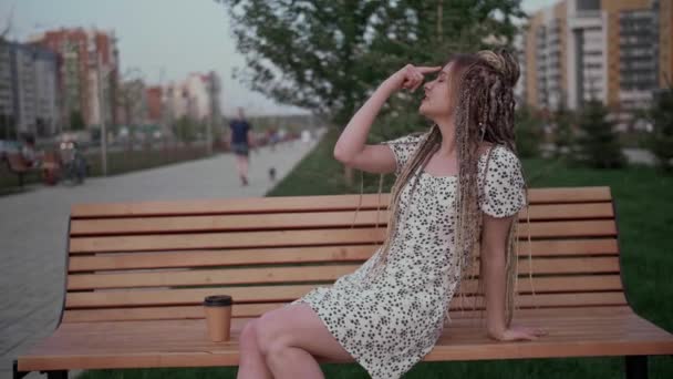 Chica joven con rastas posando en un banco — Vídeos de Stock