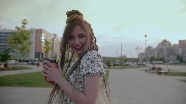 Chica joven con rastas con café paseos por la calle — Vídeos de Stock